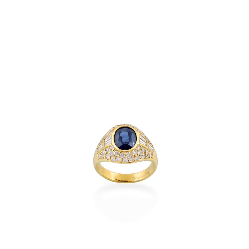 Anello in oro giallo 18 kt con pavé di brillanti, diamanti taper e zaffiro ovale centrale