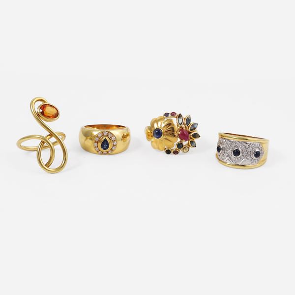 18KT GOLD LOT OF FOUR RINGS WITH DIAMONDS, SAPPHIRES, RUBIES AND COLORLESS SYNTHETIC GEMS