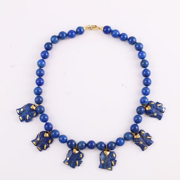 A SINGLE STRAND OF LAPISLAZULI NECKLACE WITH 18KT GOLD CLASP AND GOLDEN META PENDANTS