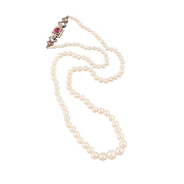 A SINGLE STRAND OF PEARLS. 18KT GOLD CLASP WITH RUBY AND DIAMONDS