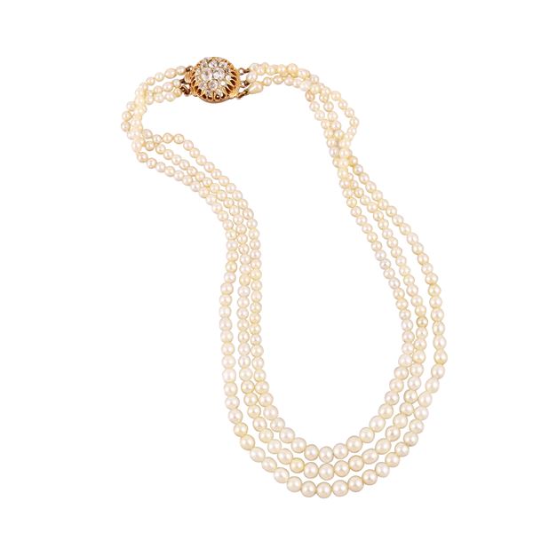 A three-strand graduated necklace composed of 268 natural saltwater pearls and 8 cultured pearls, with a yellow gold clasp set with old mine cushion-cut diamonds