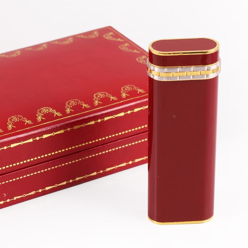 Cartier, Accendino placcato oro e lacca bordeaux, firmato, 6,9 x 2,4 x 1,2 cm