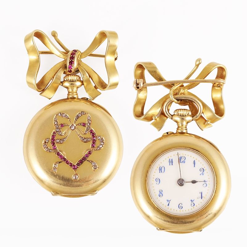 Spilla con orologio pendente in oro giallo, ornata da diamanti e rubini