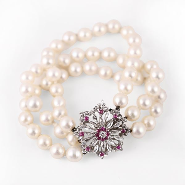 A THREE-STRAND CULTURED PEARL BRACELET WITH A 18KT GOLD CLASP SET WITH RUBIES AND DIAMOND
