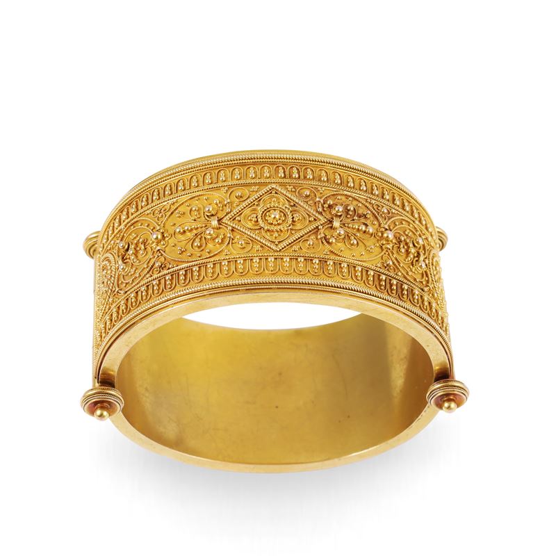 Bracciale in oro giallo 18 kt a larga fascia incernierata con decorazioni archeologiche