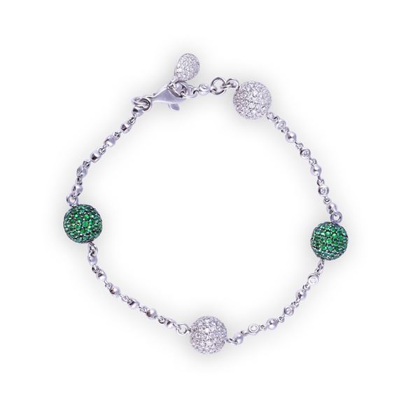 * 18KT GOLD BRACELET SET WITH DIAMONDS AND TSAVORITE GARNETS (one missing)