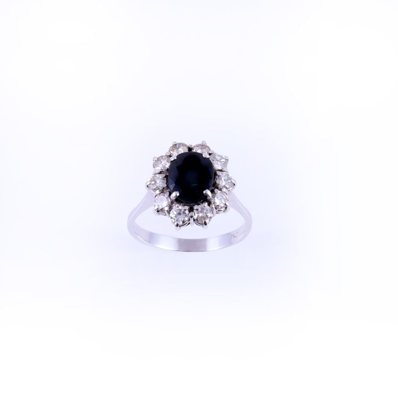 Anello in oro bianco 18 k con zaffiro ovale contornato da brillanti