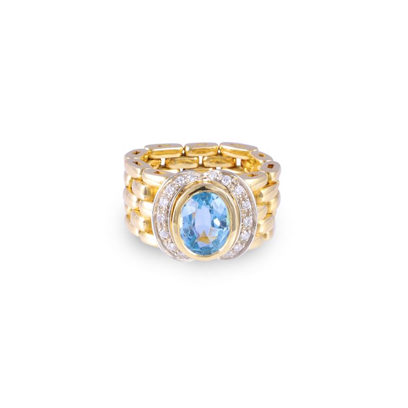 Anello, oro giallo e bianco 18 kt con topazio azzurro ovale e diamanti